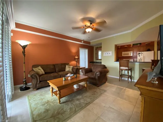 a living room with furniture a lamp and a flat screen tv