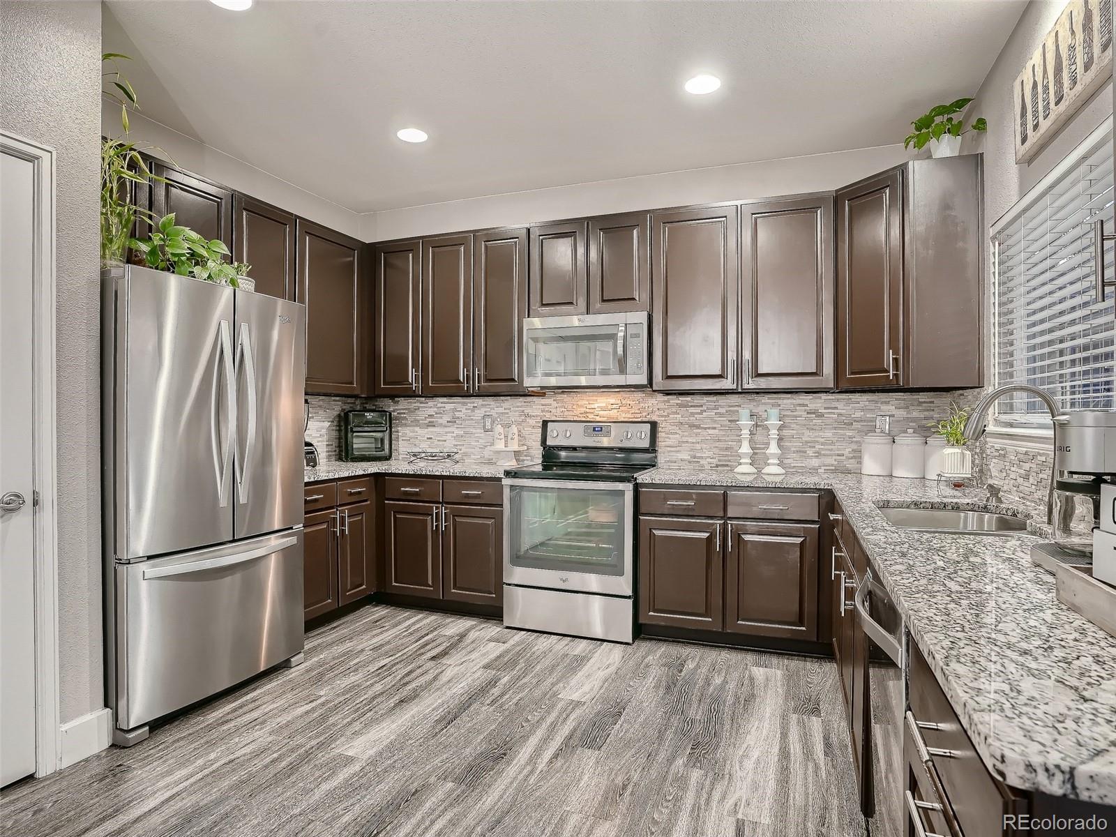 10047 Crystal Circle Commerce City, CO 80022 - Photo 11 of 28 a kitchen with granite countertop stainless steel appliances and wooden cabinets