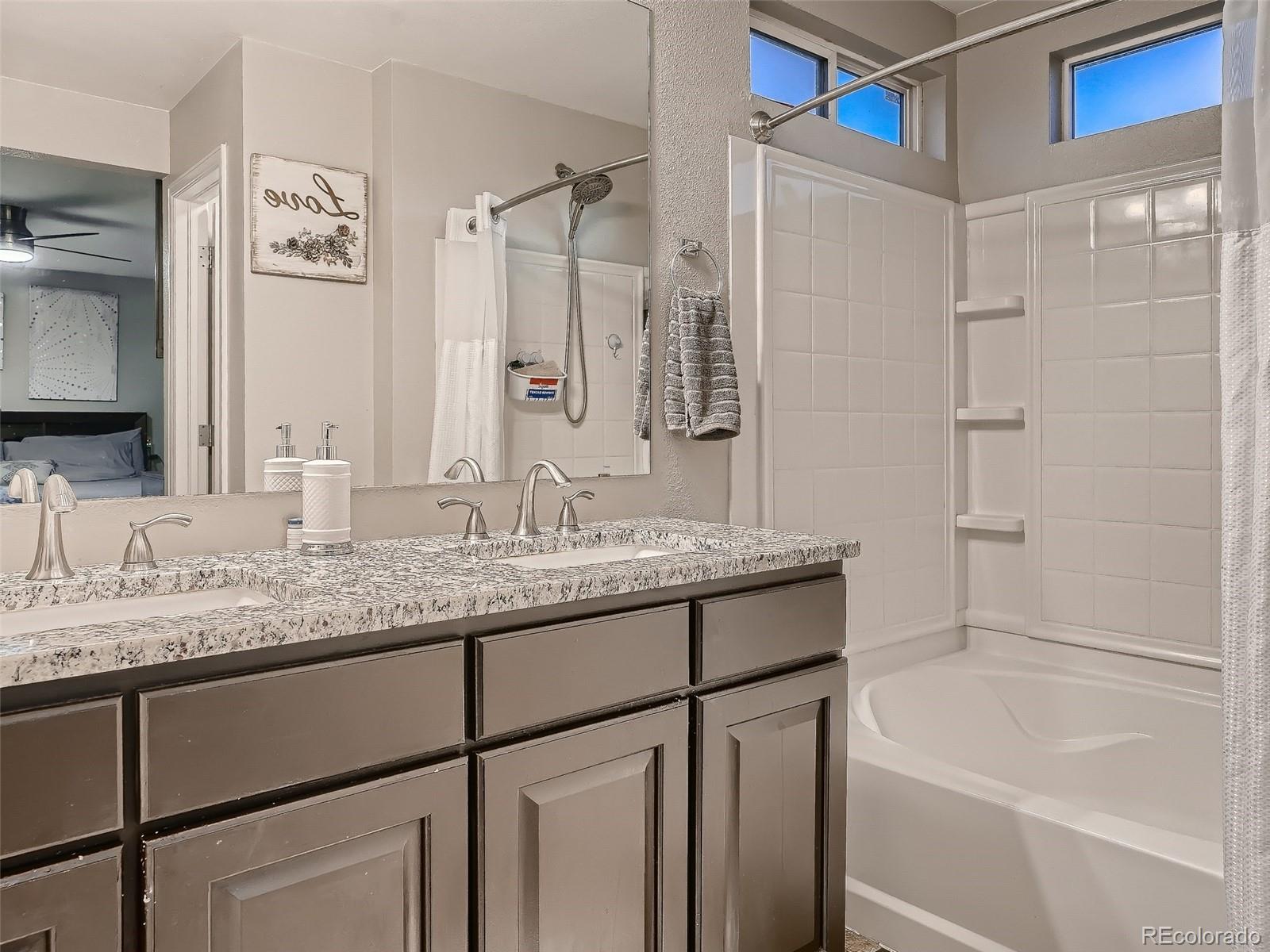 10047 Crystal Circle Commerce City, CO 80022 - Photo 18 of 28 a bathroom with a granite countertop sink mirror toilet and bathtub