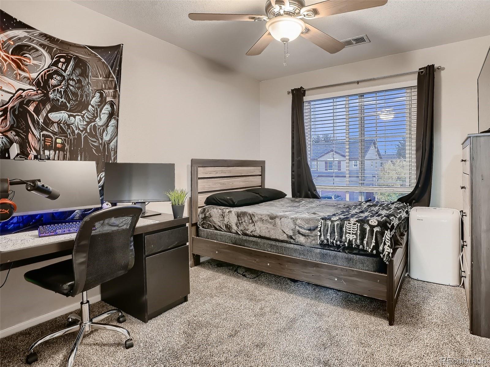 10047 Crystal Circle Commerce City, CO 80022 - Photo 20 of 28 a bedroom with a large bed and window