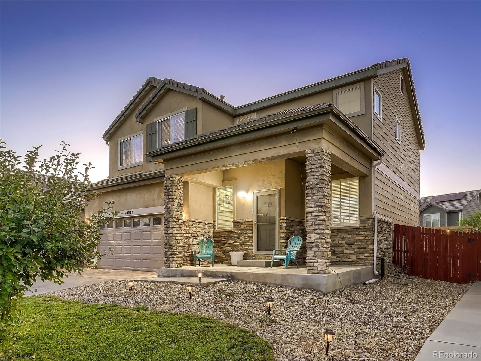 10047 Crystal Circle Commerce City, CO 80022 - Photo 2 of 28 a front view of a house with garden