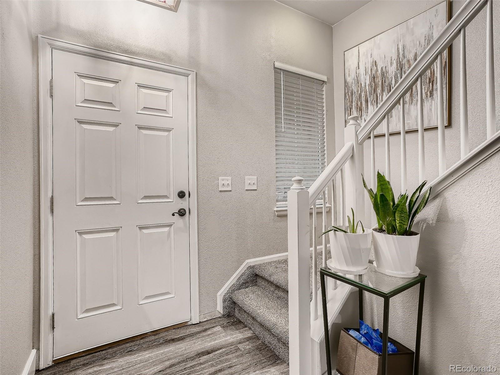 10047 Crystal Circle Commerce City, CO 80022 - Photo 3 of 28 a very nice looking hallway with white walls and stairs