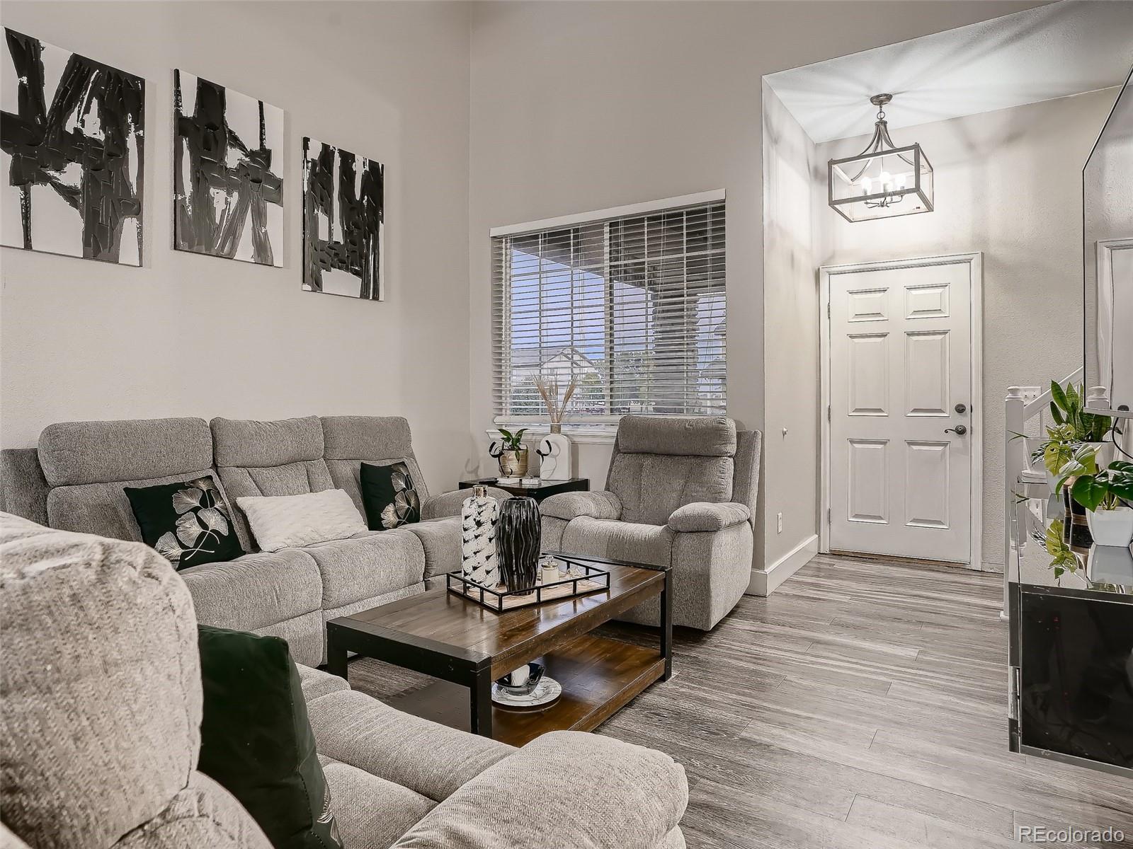 10047 Crystal Circle Commerce City, CO 80022 - Photo 5 of 28 a living room with furniture and wooden floor