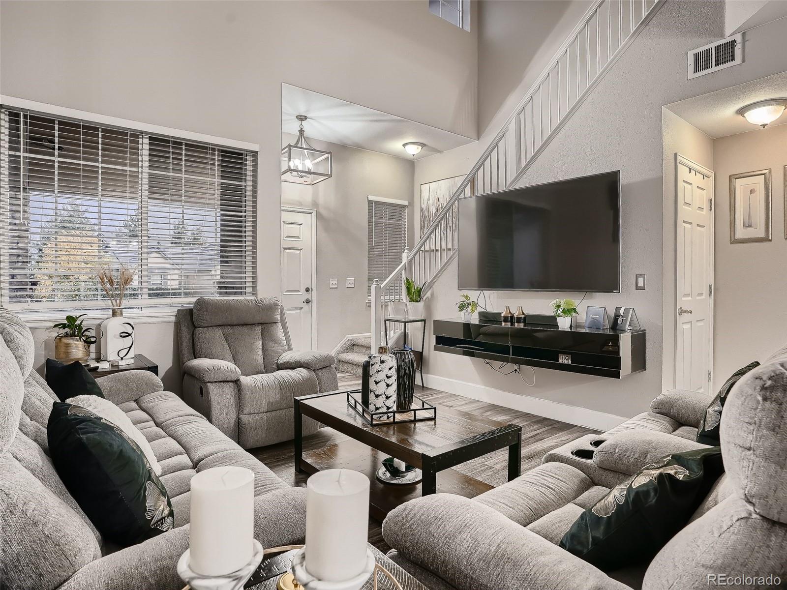 10047 Crystal Circle Commerce City, CO 80022 - Photo 6 of 28 a living room with furniture and a flat screen tv