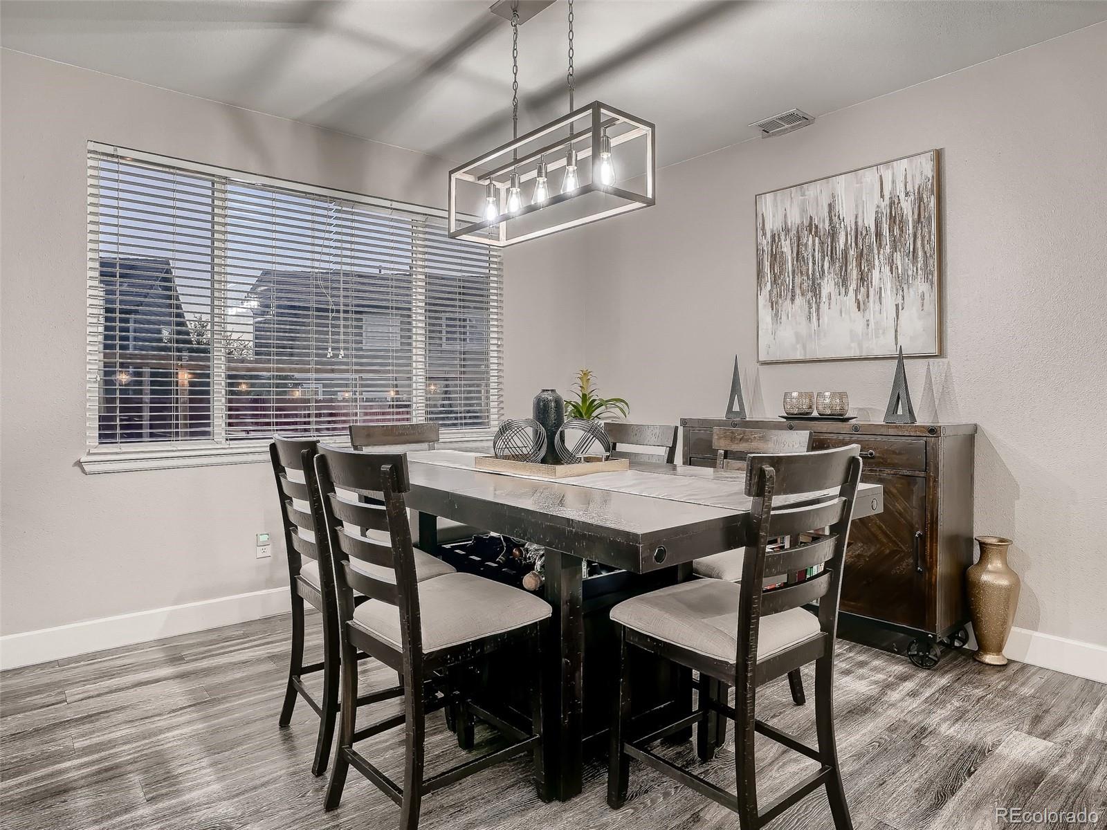10047 Crystal Circle Commerce City, CO 80022 - Photo 7 of 28 a view of a dining room with furniture window and wooden floor