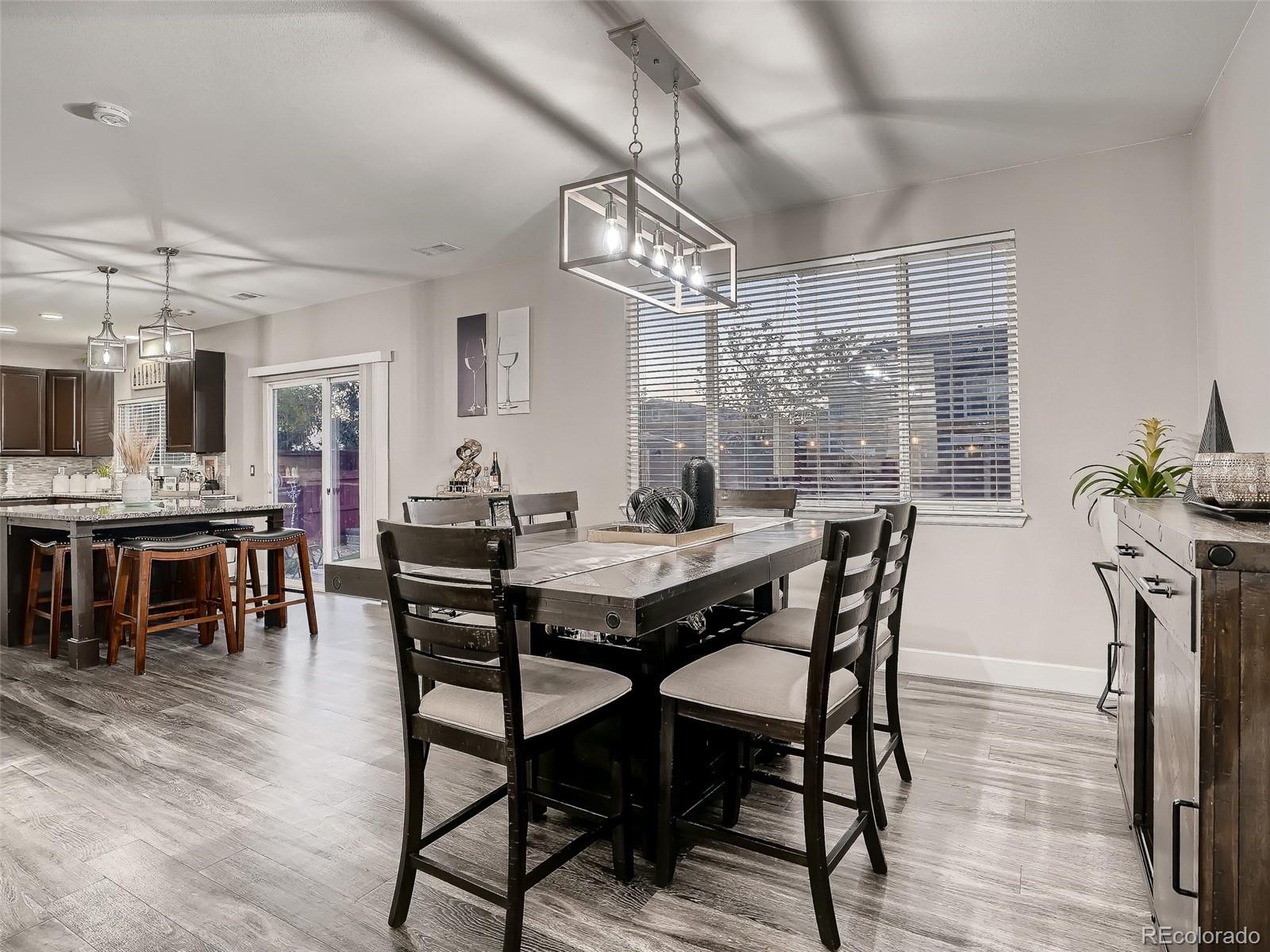 10047 Crystal Circle Commerce City, CO 80022 - Photo 8 of 28 a view of a dining room with furniture window and wooden floor