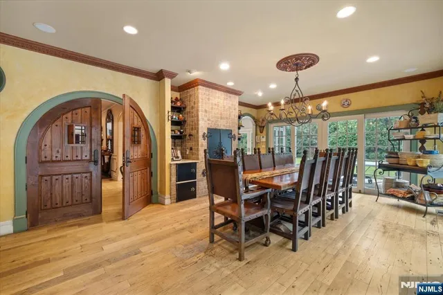 a view of a kitchen with kitchen island stainless steel appliances wooden floor dining table and chairs