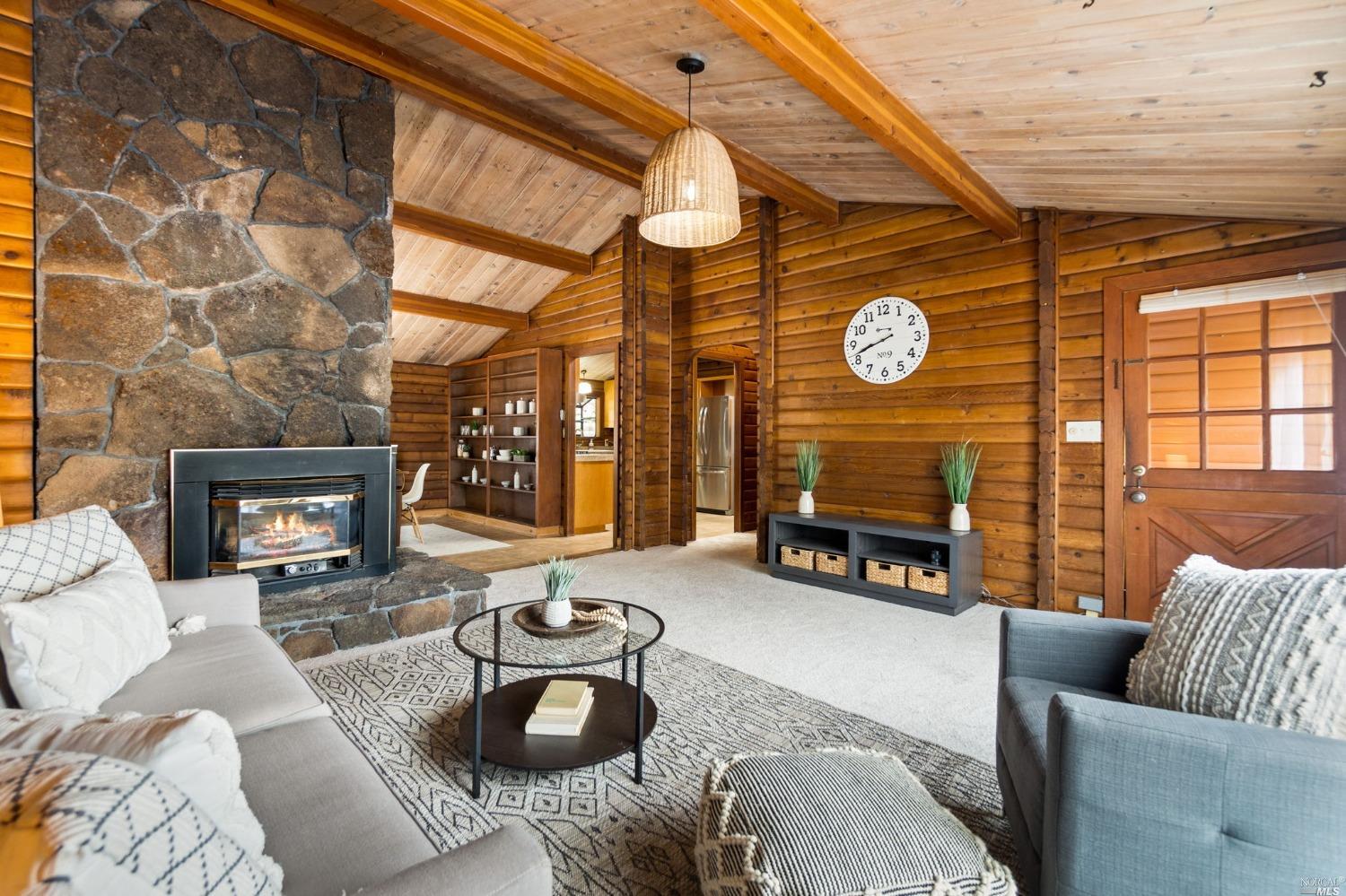 a living room with furniture a fireplace and a large window