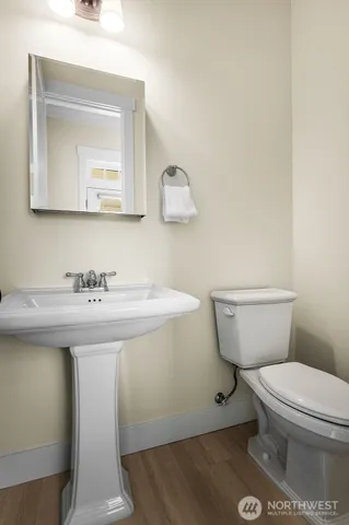 a bathroom with a toilet a sink and mirror
