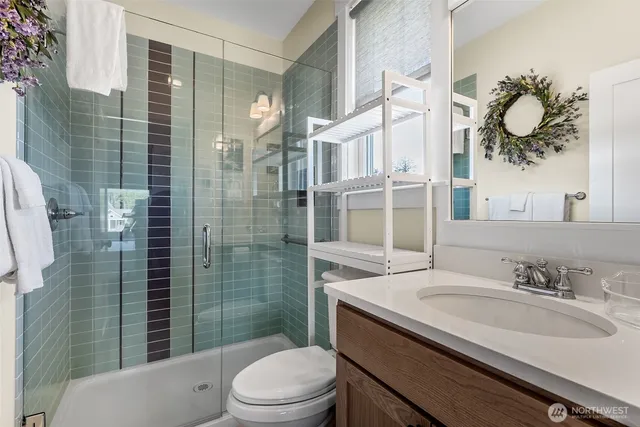 a bathroom with a granite countertop sink toilet a mirror and shower