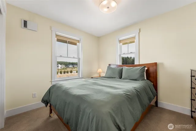 a bed sitting in a bedroom next to a window