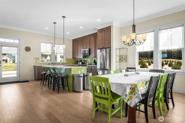a view of a dining room and livingroom with furniture wooden floor a chandelier