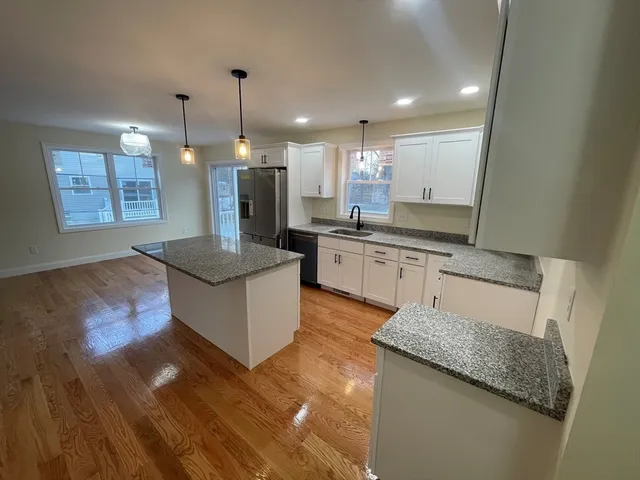 a large kitchen with granite countertop a stove and a sink