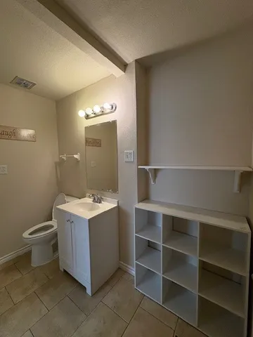 a bathroom with a toilet sink and mirror