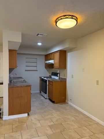 a kitchen with stainless steel appliances granite countertop a stove a sink and a microwave