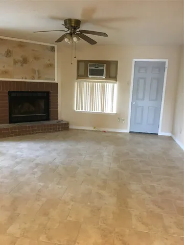 an empty room with windows and fireplace