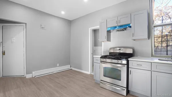 a kitchen with white cabinets and a stove top oven
