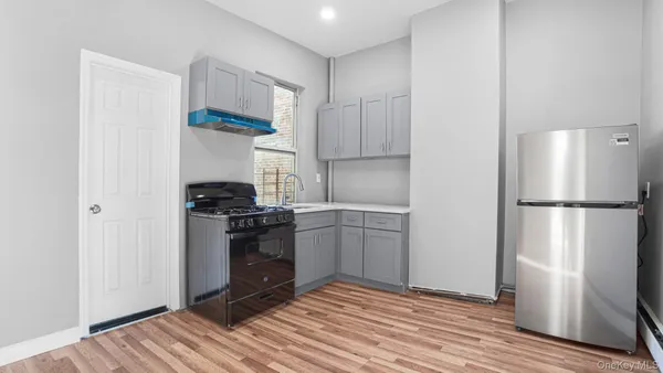a kitchen with a refrigerator and a stove top oven