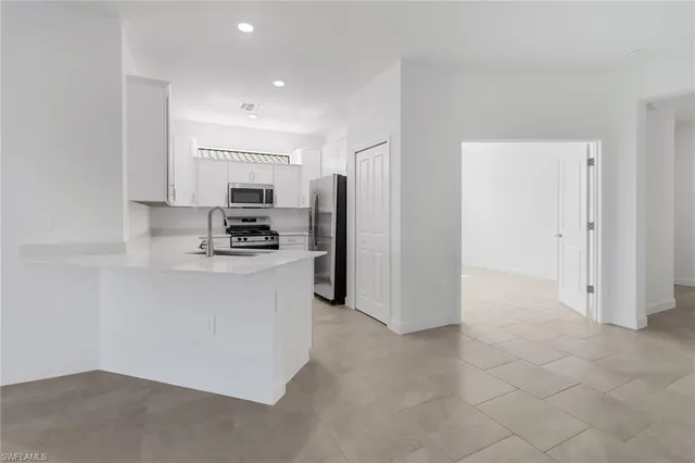 a kitchen with stainless steel appliances a refrigerator and a stove top oven