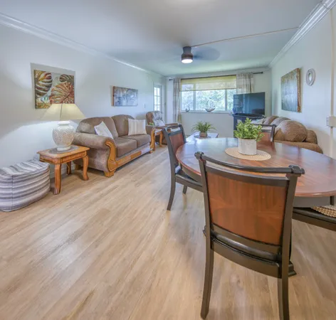 a living room with furniture a dining table and paintings on the wall