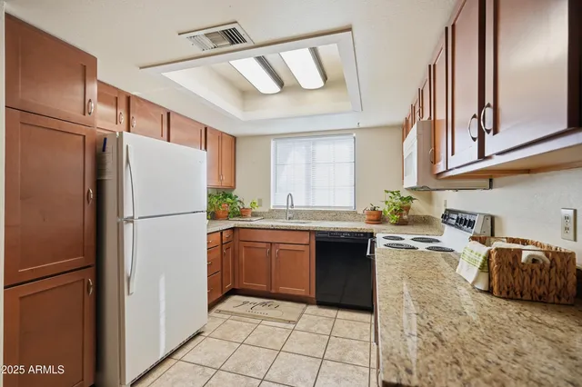 a kitchen with granite countertop a refrigerator and a sink