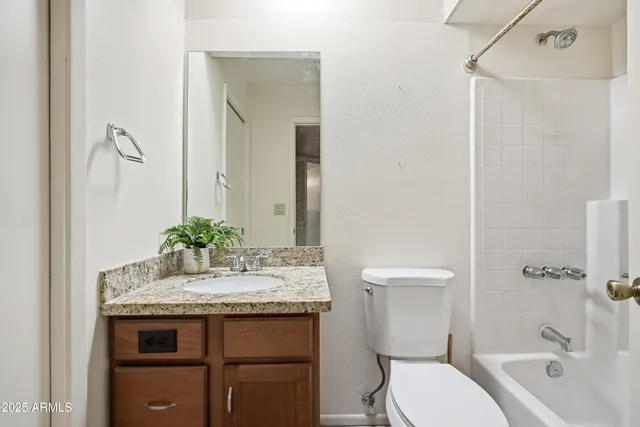 a bathroom with a granite countertop sink toilet and shower