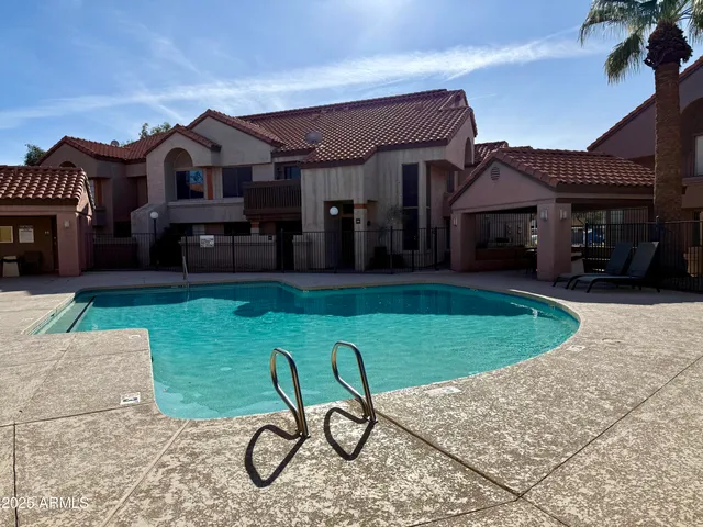 a view of a chair and table in backyard of the house