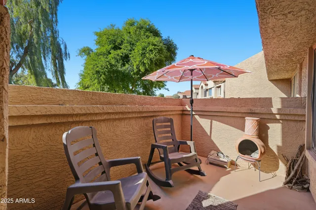 a view of patio with table and chairs under an umbrella