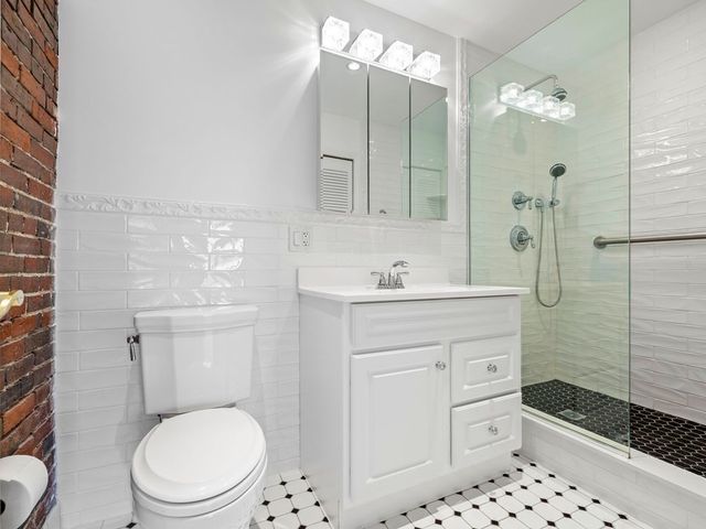 a bathroom with a sink toilet vanity and shower