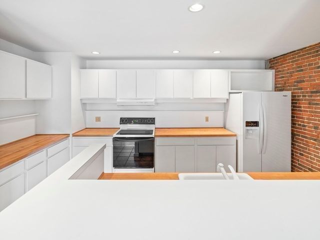 a kitchen with stainless steel appliances granite countertop a refrigerator sink and stove