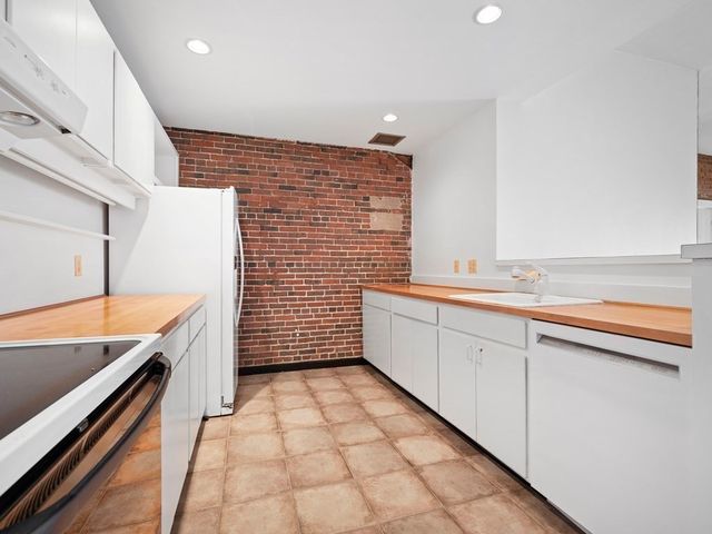 a bathroom with a granite countertop sink and a bathtub
