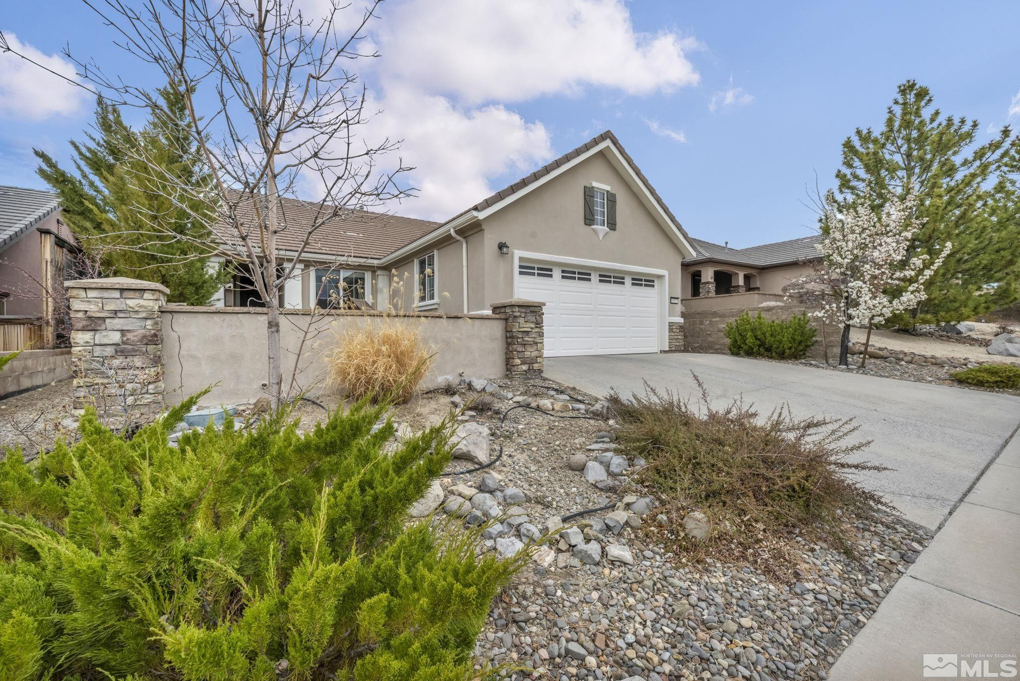 a front view of a house with a yard and large tree