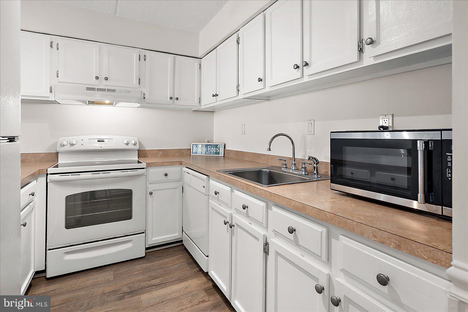 10300 Coastal Highway, Unit 1808 Ocean City, MD 21842 - Photo 14 of 47 a kitchen with cabinets stainless steel appliances and sink