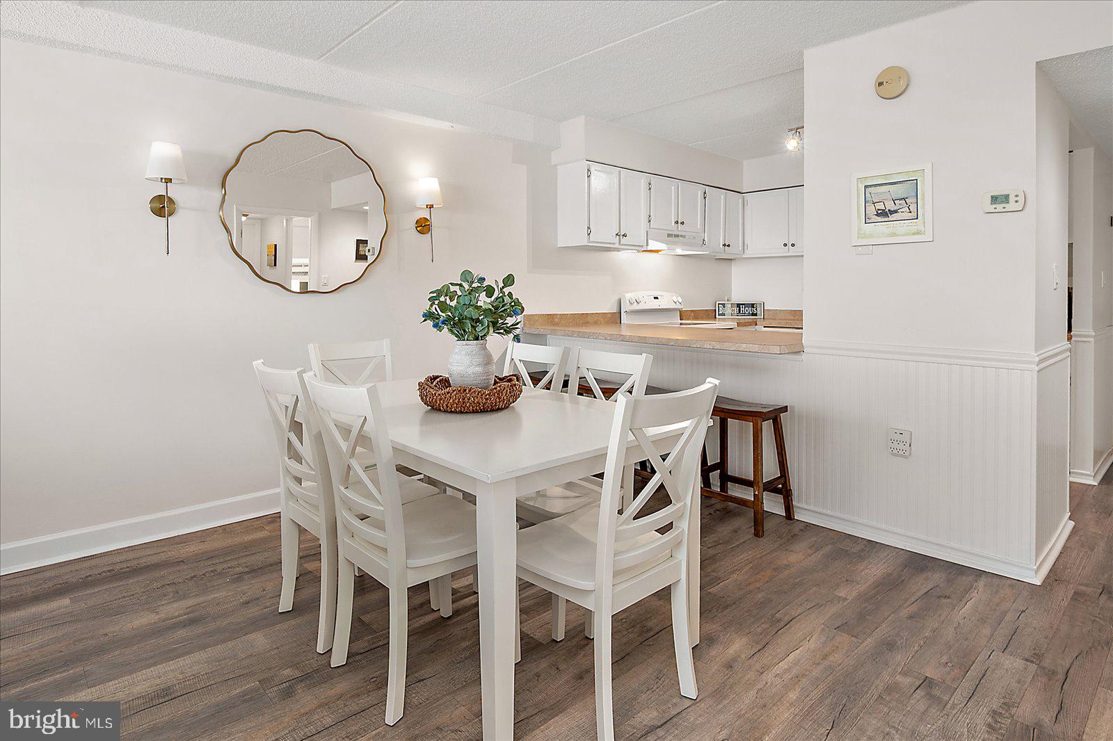 10300 Coastal Highway, Unit 1808 Ocean City, MD 21842 - Photo 19 of 47 a dining room with wooden floor a glass table and chairs