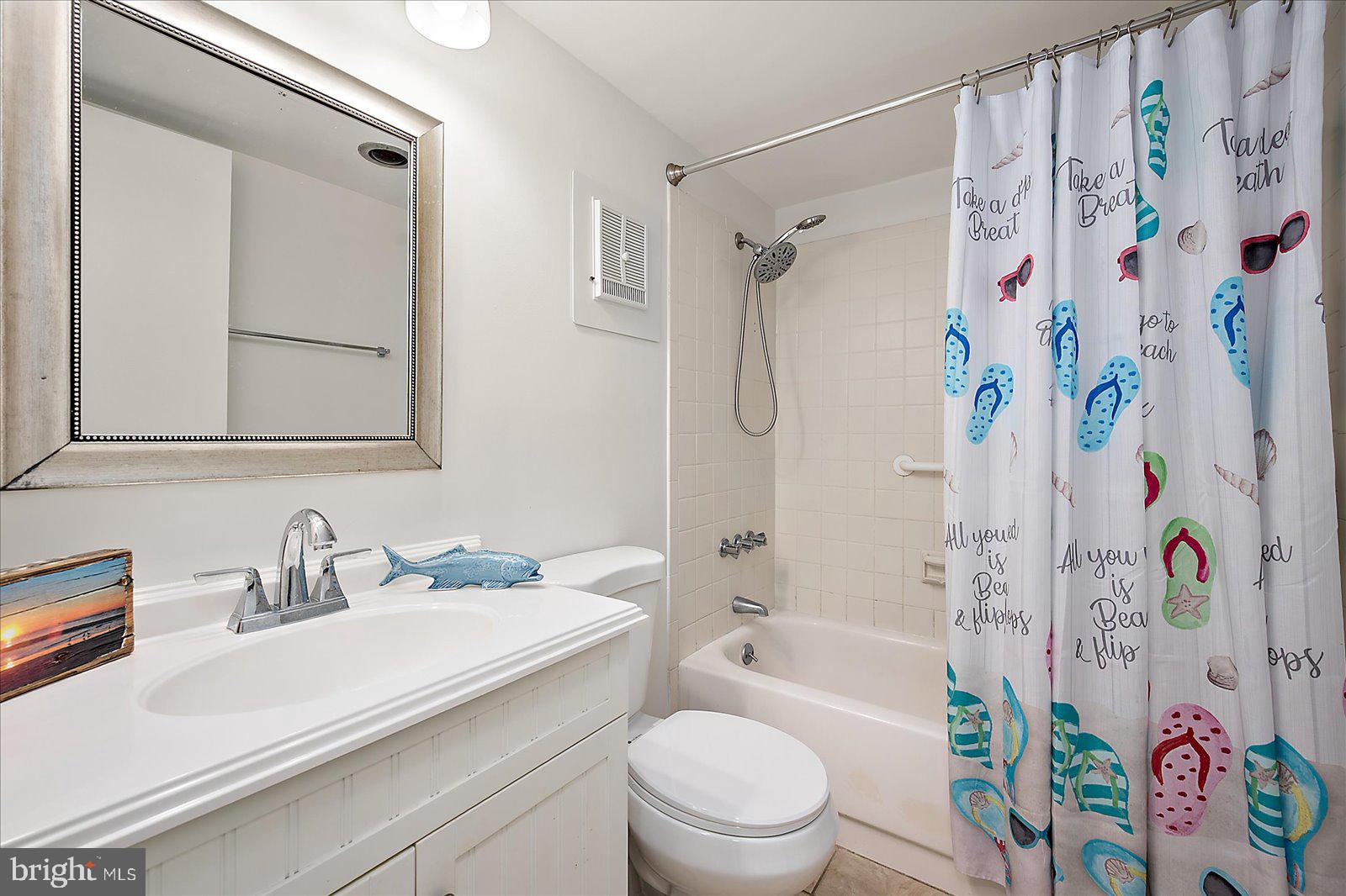 10300 Coastal Highway, Unit 1808 Ocean City, MD 21842 - Photo 27 of 47 a bathroom with a sink a toilet and a bathtub with shower