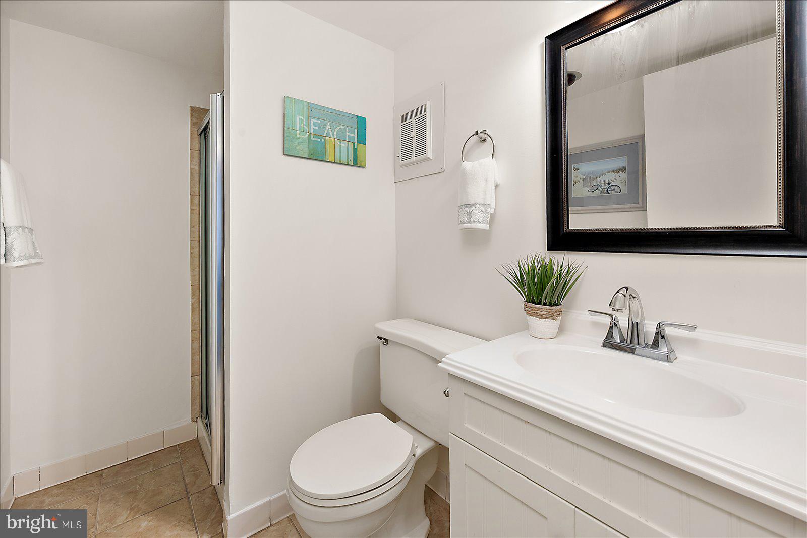 10300 Coastal Highway, Unit 1808 Ocean City, MD 21842 - Photo 33 of 47 a bathroom with a toilet sink and mirror