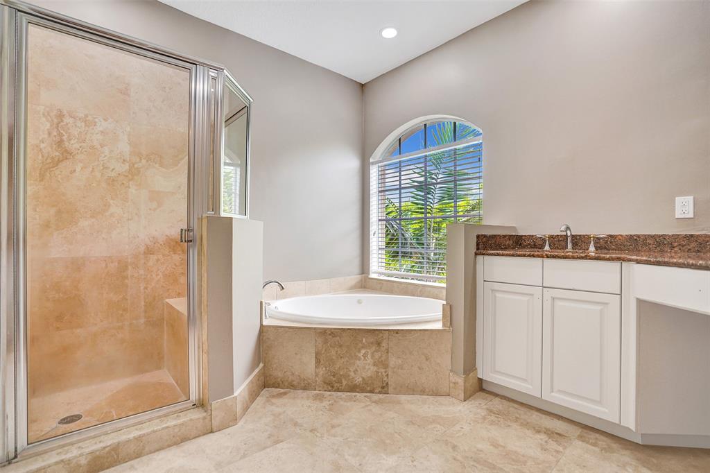 230 Northeast 69th Circle, Unit 230 Boca Raton, FL 33487 - Photo 36 of 91 a spacious bathroom with a bathtub a shower and a window