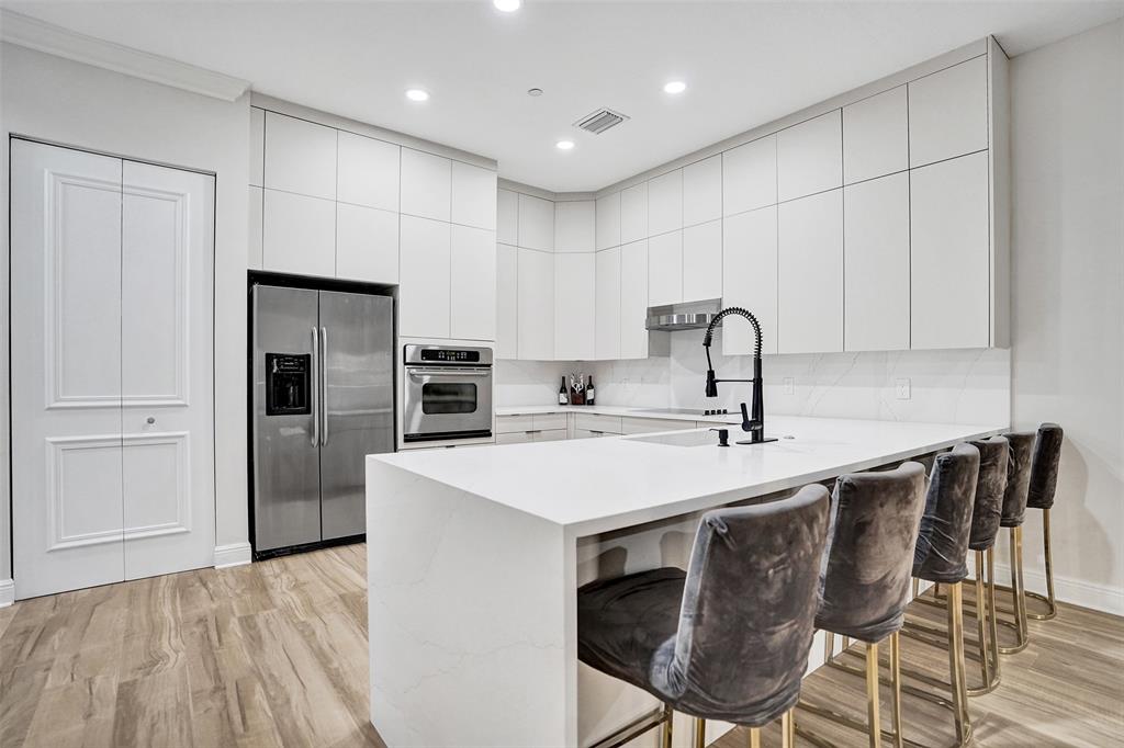 230 Northeast 69th Circle, Unit 230 Boca Raton, FL 33487 - Photo 6 of 91 a kitchen with stainless steel appliances a sink a stove a refrigerator cabinets and a dining table
