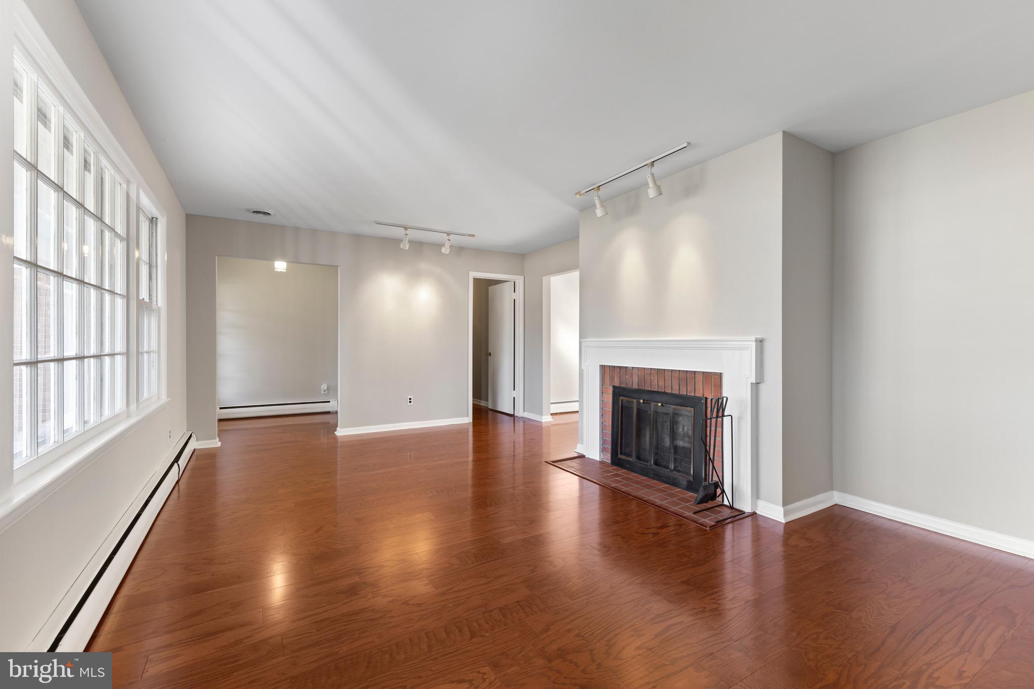412 Vierling Drive Silver Spring, MD 20904 - Photo 12 of 35 an empty room with wooden floor fireplace and windows