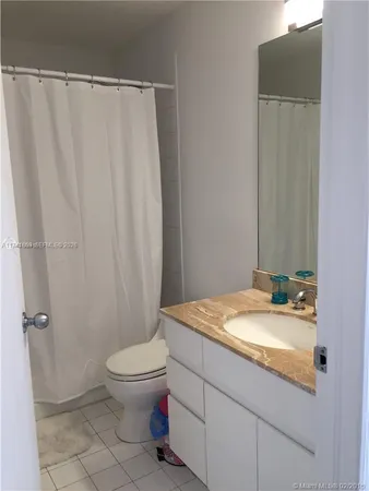 a bathroom with a granite countertop sink toilet and a mirror