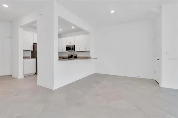 an empty room with ceiling fan and window