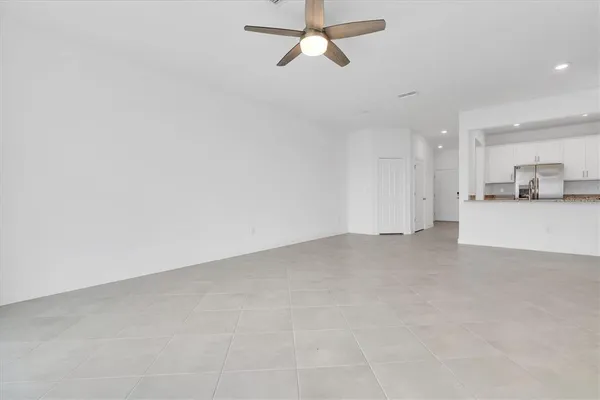 an empty room with windows and fan