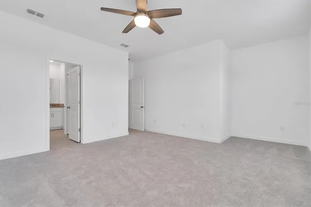 an empty room with a ceiling fan and a window