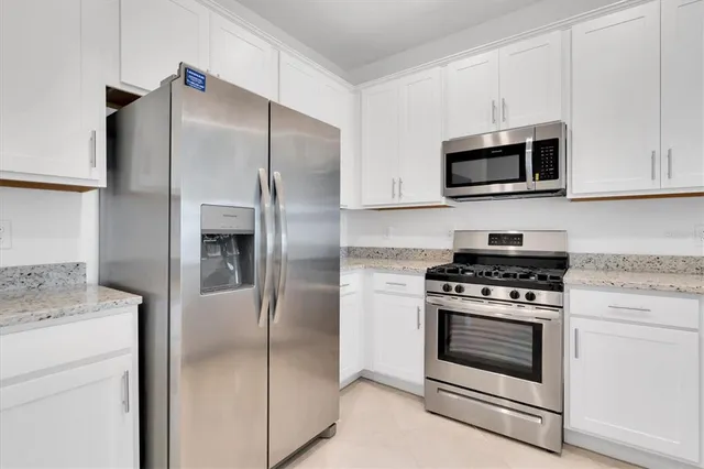 a kitchen with white cabinets and stainless steel appliances