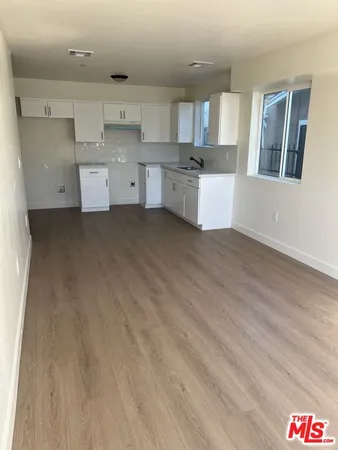 a kitchen with cabinets and wooden floor