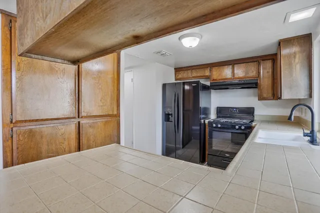 a kitchen with stainless steel appliances granite countertop a refrigerator and a stove
