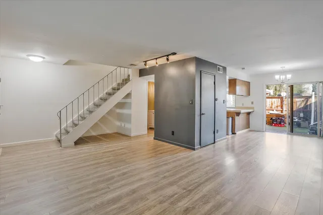 a view of an empty room with wooden floor and a cabinet