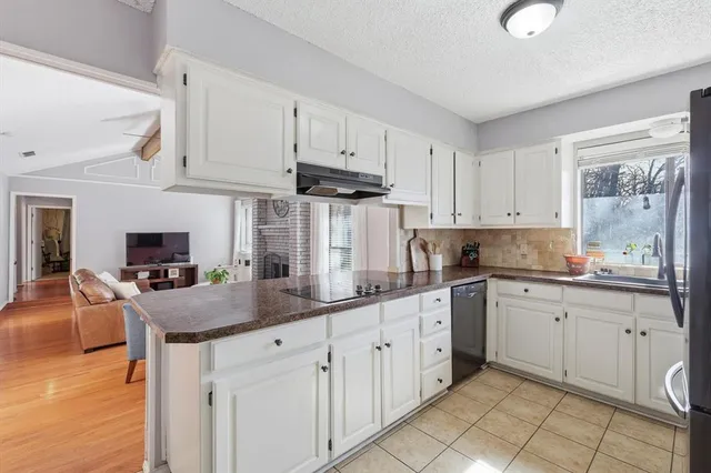 a kitchen with granite countertop white cabinets white appliances and sink