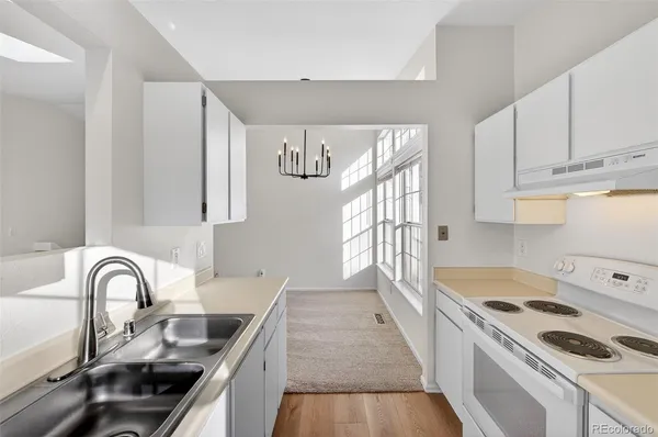 a kitchen with a sink a stove cabinets and stainless steel appliances