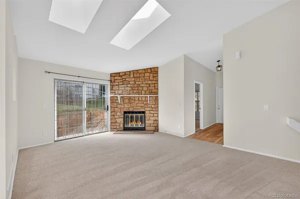 a view of an empty room with a fireplace and a window